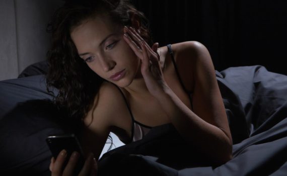 Femme au lit avec son smartphone